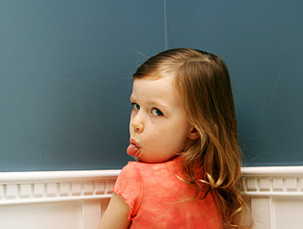 ילדה בפינה מוציאה לשון (צילום: Brad Killer, Istock)