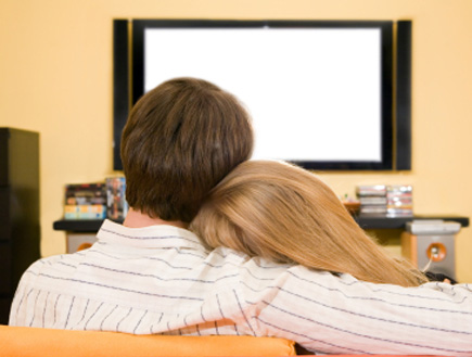 זוג מתחבק מול טלויזיה ברקע (צילום: DrGrounds, Istock)
