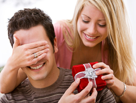 אשה עוצמת את עיני בעלה ומפתיעה אותו במתנה (צילום: istockphoto)