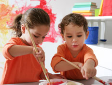 שני ילדים לבושים כתום מציירים (צילום: Weekend Images Inc., Istock)
