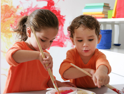 שני ילדים לבושים כתום מציירים (צילום: Weekend Images Inc., Istock)