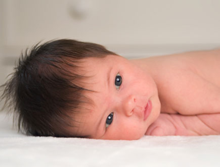 תינוק בן יומו שוכב על הבטן ובוהה (צילום: Nathan Maxfield, Istock)