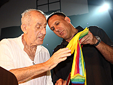 דורון ג'מצ'י מעניק לרלף קליין תיק בצבעי דגל הגאווה (צילום: עודד קרני)