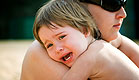 ילד בוכה ומחבק את אמו (צילום: AlexMotrenko, Istock)