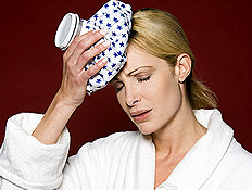 אישה בחלוק לבן שמה קרח נגד כאב ראש (צילום: jupiter images)