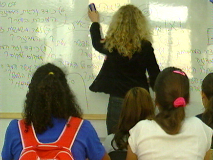 מורה בכיתה כותבת על הלוח, 2 תלמידות מקשיבות (וידאו WMV: חדשות)