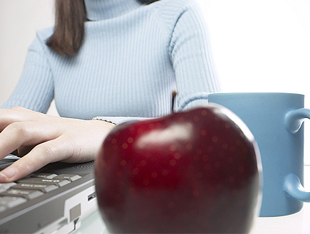 אישה מקלידה על מחשב עם כוס קפה ותפוח (וידאו WMV: jupiter images)