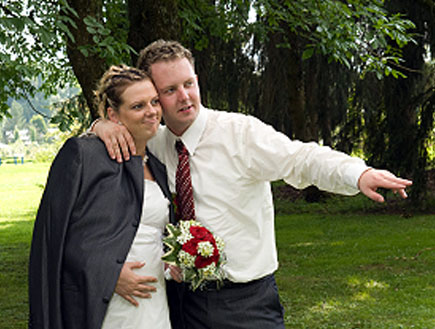 חתן וכלה בהריון מחובקים ביום חתונתם על הדשא (צילום: jupiter images)