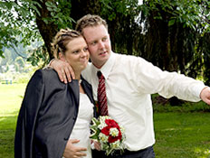חתן וכלה בהריון מחובקים ביום חתונתם על הדשא (צילום: jupiter images)