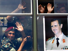 חיילים סוריים מנפנפים מבעד לחלון אוטובוס (צילום: חדשות)