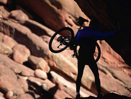 דמות עם אופניים על הכתף על רקע הר (צילום: John Foxx, GettyImages IL)