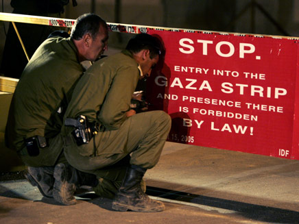 חיילים מציבים שלט במחסום כיסופים בעזה (צילום: רויטרס)