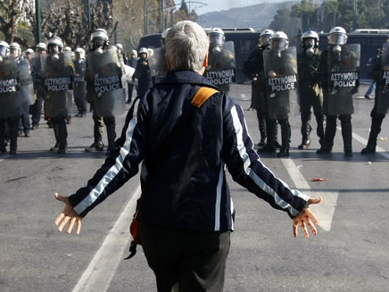 מפגינה מול שוטרים במהומות ביוון (צילום: רויטרס)