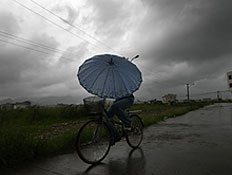 אופניים בגשם (צילום: China Photos, GettyImages IL)