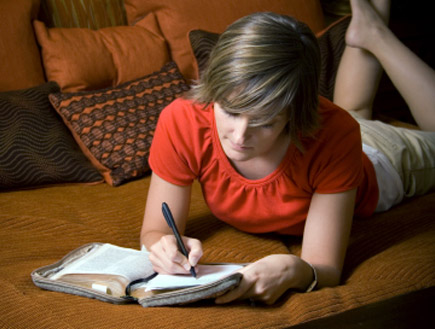 בחורה כותבת מכתב על ספה (צילום: Loretta Hostettler, Istock)