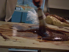 השוקולטייה רואי גרשון מטמפרר את השוקולד המומס (צילום: נועה אסטרייכר)