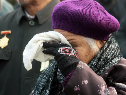 קשישה מסתירה את פניה (רויטרס) (צילום: רויטרס)