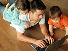 אבא עם מחשב נייד ושני ילדיו (צילום: dagmar heymans, Istock)