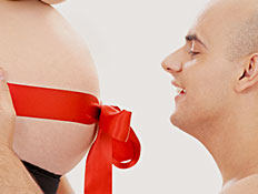 זוג בהריון עם סרט אדום על הבטן (צילום: Lev Dolgatshjov, Istock)