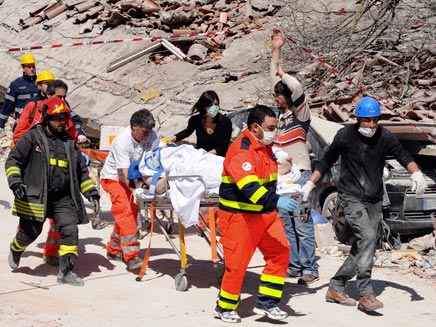 כוחות חילוץ מפנים פצועים לאחר רעידת אדמה באיטליה (צילום: רויטרס)