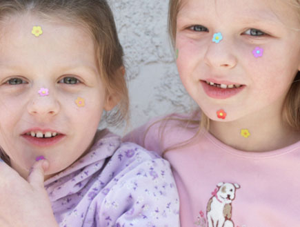 ילדות מדביקות מדבקות על הפנים (צילום: Paige Falk, Istock)