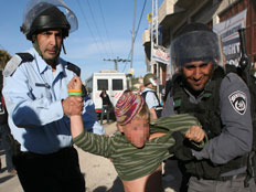 שוטרים אוחזים בכוח ילד מתנחל בחברון (צילום: רויטרס)