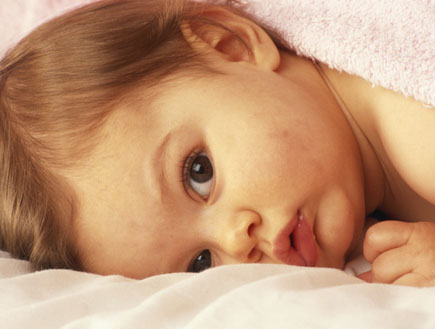 תינוקת חמודה שוכבת במיטה (צילום: David De Lossy, GettyImages IL)