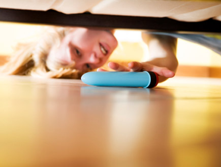 אשה מחביאה ויברטור מתחת למיטה (צילום: diego_cervo, Istock)