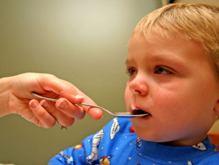 ילד חולה עם כפית בפה (צילום: DIGIcal, Istock)