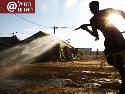 חייל משפריץ מים בבסיס של צה"ל (צילום: רויטרס)