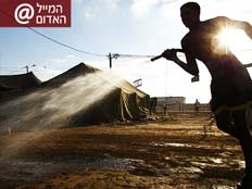 חייל משפריץ מים בבסיס של צה"ל (צילום: רויטרס)