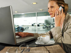 אשה עם מחשב ופלאפון בשדה תעופה (צילום: John Rowley, GettyImages IL)