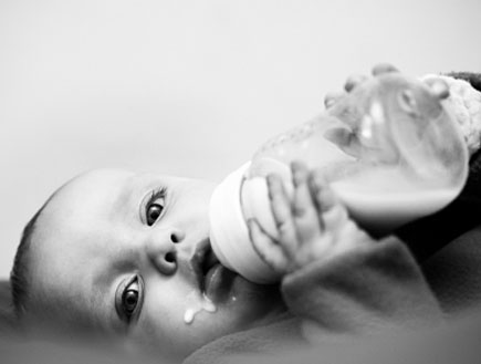 תינוק מחזיק בקבוק חלב (צילום: RapidEye, Istock)