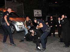 שוטרים עוצרים מפגין חרדי (צילום: אתר חרדים)