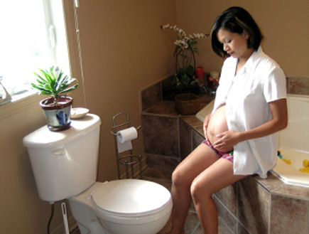 אשה בהריון יושבת בשירותים (צילום: istockphoto)