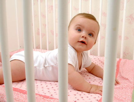 תינוקת עירנית בעריסה (צילום: LisaValder, Istock)