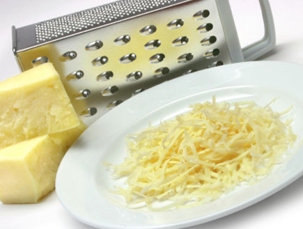 צלחת עם גבינה צהובה מגורדת ומגרדת ליד (צילום: istockphoto)
