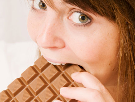 אישה נוגסת בטבלת שוקולד (צילום: RichHobson, Istock)