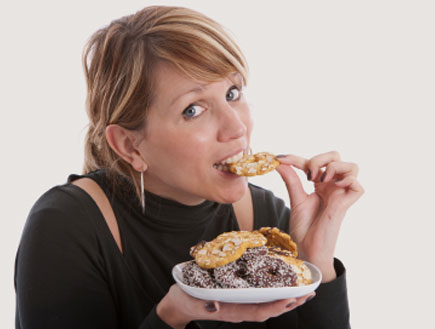 אישה אוכלת עוגיות (צילום: Simone Van den berg, Istock)