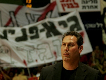 גודס על רקע השלטים של אוהדי ירושלים נגד גיא פניני (אמיר לוי) (צילום: מערכת ONE)