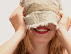 אישה נבוכה - כובע על הפנים (צילום: Sharon Dominick, Istock)
