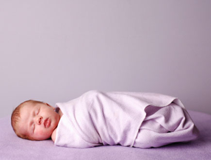 תינוק עטוף בשמיכה סגולה (צילום: ideabug, Istock)