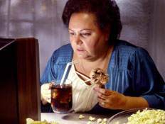אישה אוכלת מול הטלויזיה (צילום: KenTannenbaum, Istock)
