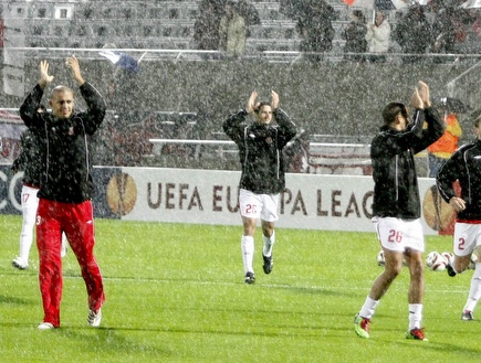 שחקני הפועל מתחממים תחת הגשם השוטף (אמיר לוי) (צילום: מערכת ONE)