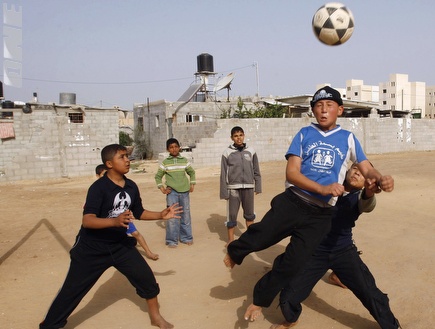 ילדים פלסטינים משחקים כדורגל בחאן יונס (רויטרס) (צילום: מערכת ONE)