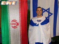 סרג´יו בריטבה עטוף בדגל ישראל, על רקע הדגל איראן (צילום: מערכת ONE)