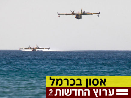 מטוסי כיבוי אוספים מים מהים לכיבוי השריפה בכרמל (צילום: רויטרס)