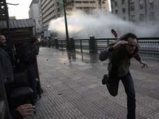 מפגין נמלט מגז מדמיע, היום בקהיר (צילום: AP)