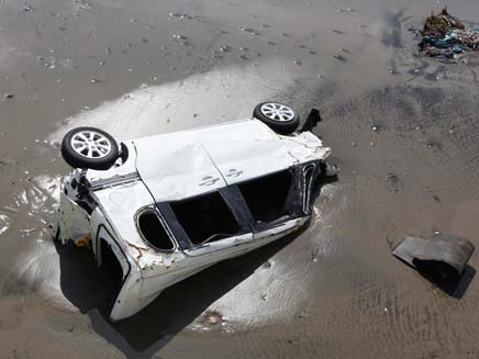 רכב נשטף בתוך המים (צילום: AP)