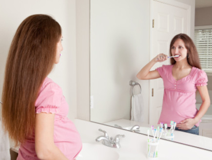 אישה בהריון מצחצחת שיניים (צילום: Sharon Dominick, Istock)